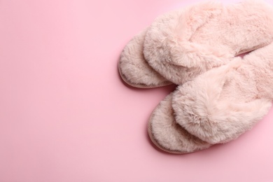 Photo of Pair of stylish soft slippers on pink background, flat lay. Space for text