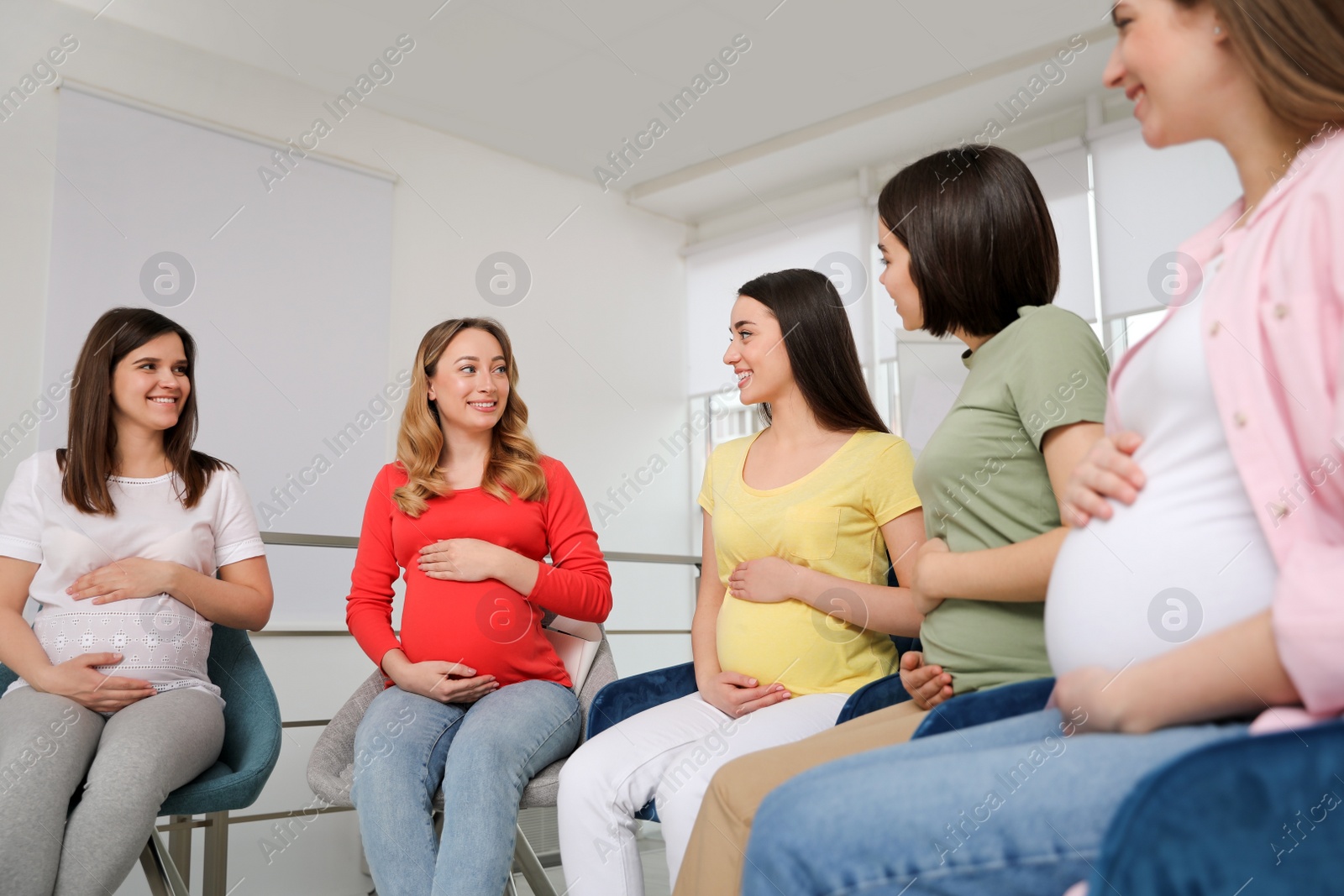 Photo of Group of pregnant women at courses for expectant mothers indoors