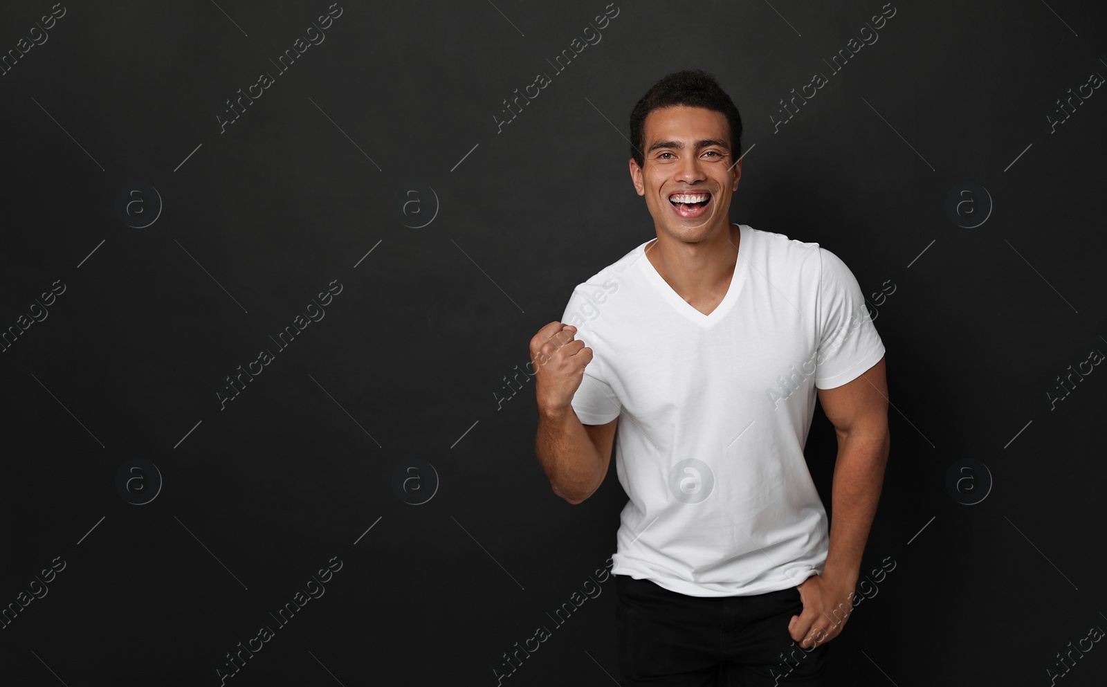 Photo of Happy handsome young African-American man on black background