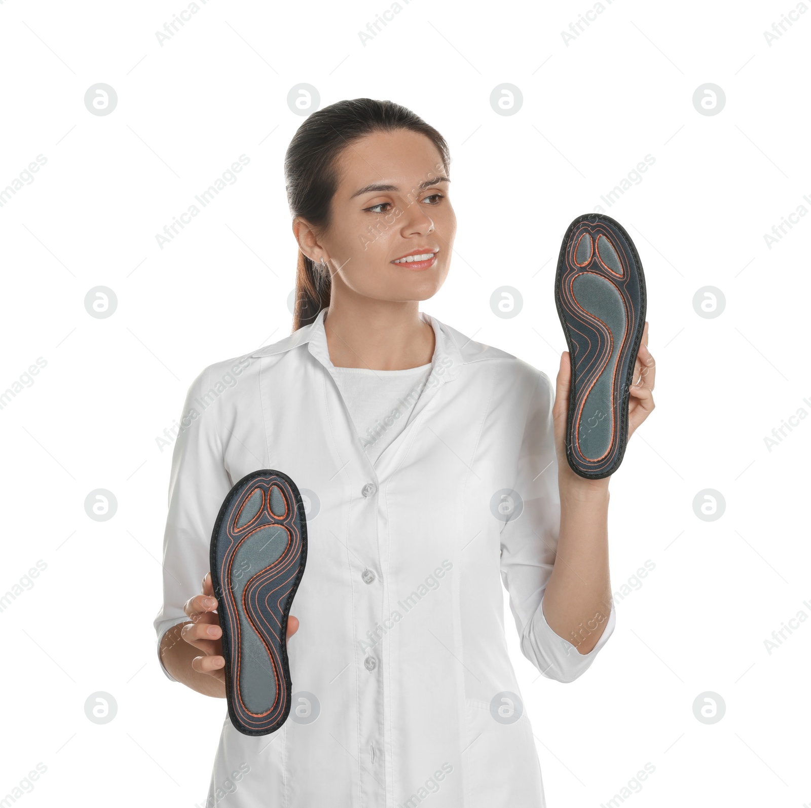 Photo of Beautiful female orthopedist showing insoles on white background