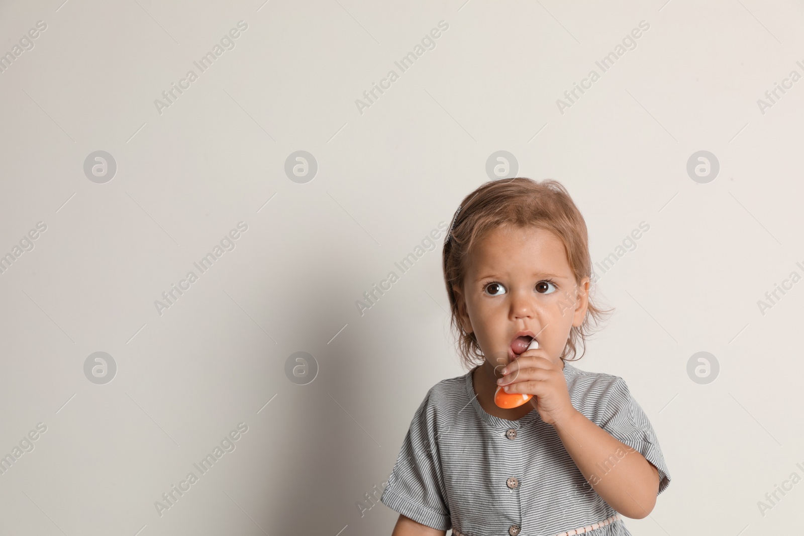 Photo of Cute little girl with toothbrush and space for text on white background