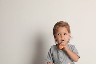 Cute little girl with toothbrush and space for text on white background