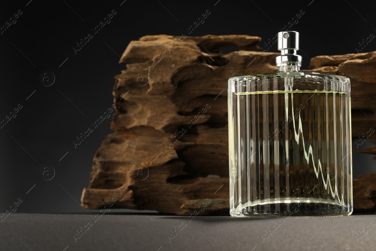 Photo of Luxury men`s perfume in bottle on grey table, space for text