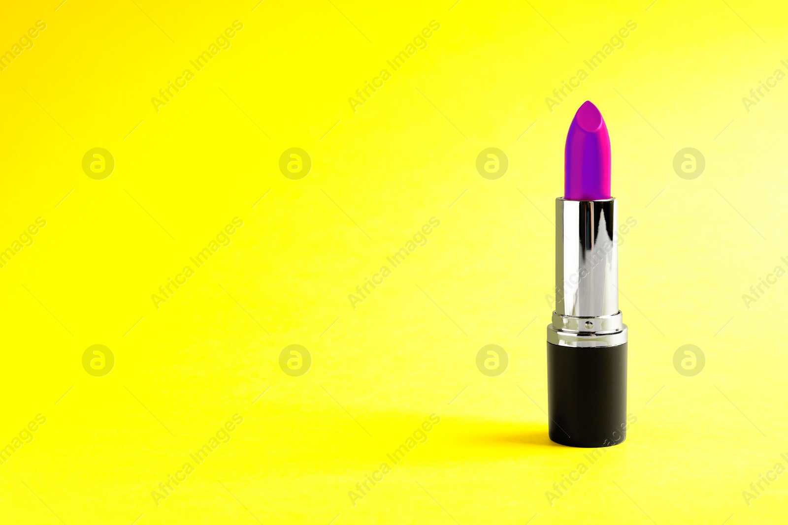 Image of Bright lipstick on yellow background. Space for text