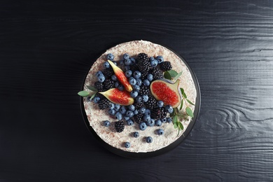 Photo of Delicious homemade cake with fresh berries on dark wooden table, top view