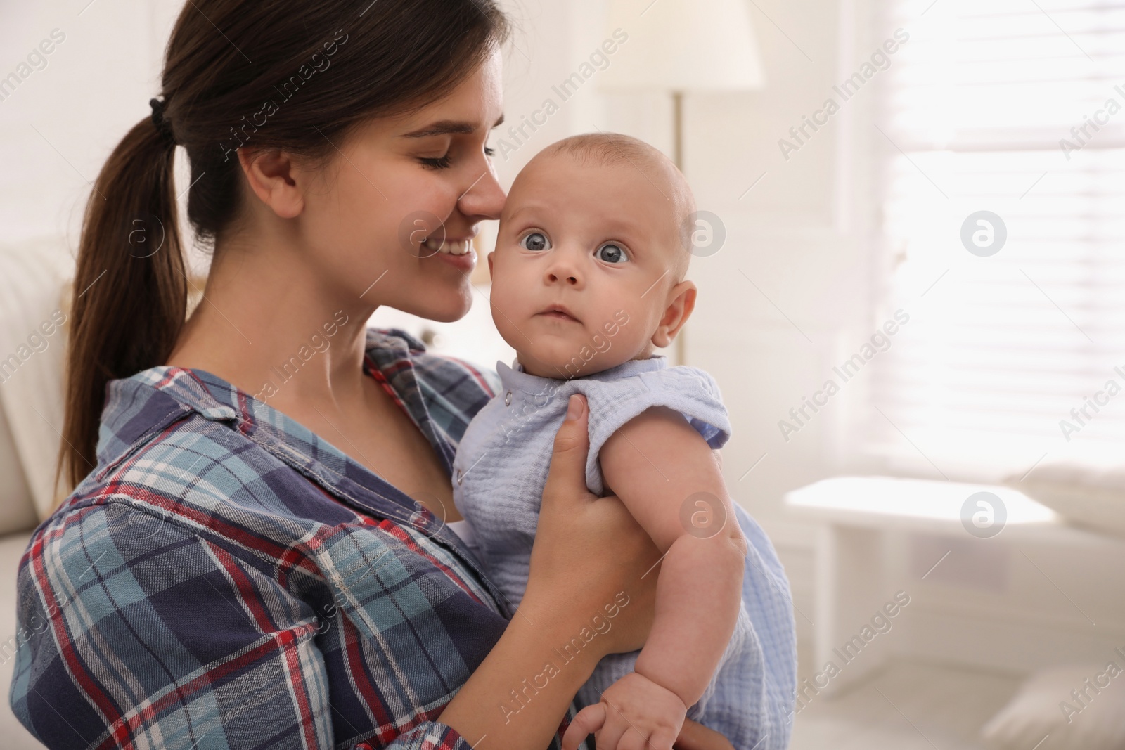 Photo of Happy young mother with her cute baby at home