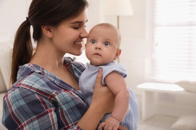 Happy young mother with her cute baby at home