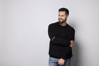 Photo of Happy man in stylish sweater on white background, space for text