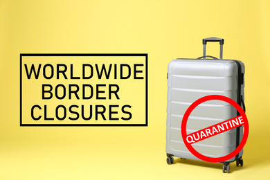 Image of Worldwide border closures through quarantine during coronavirus outbreak. Suitcase and prohibition sign on yellow background
