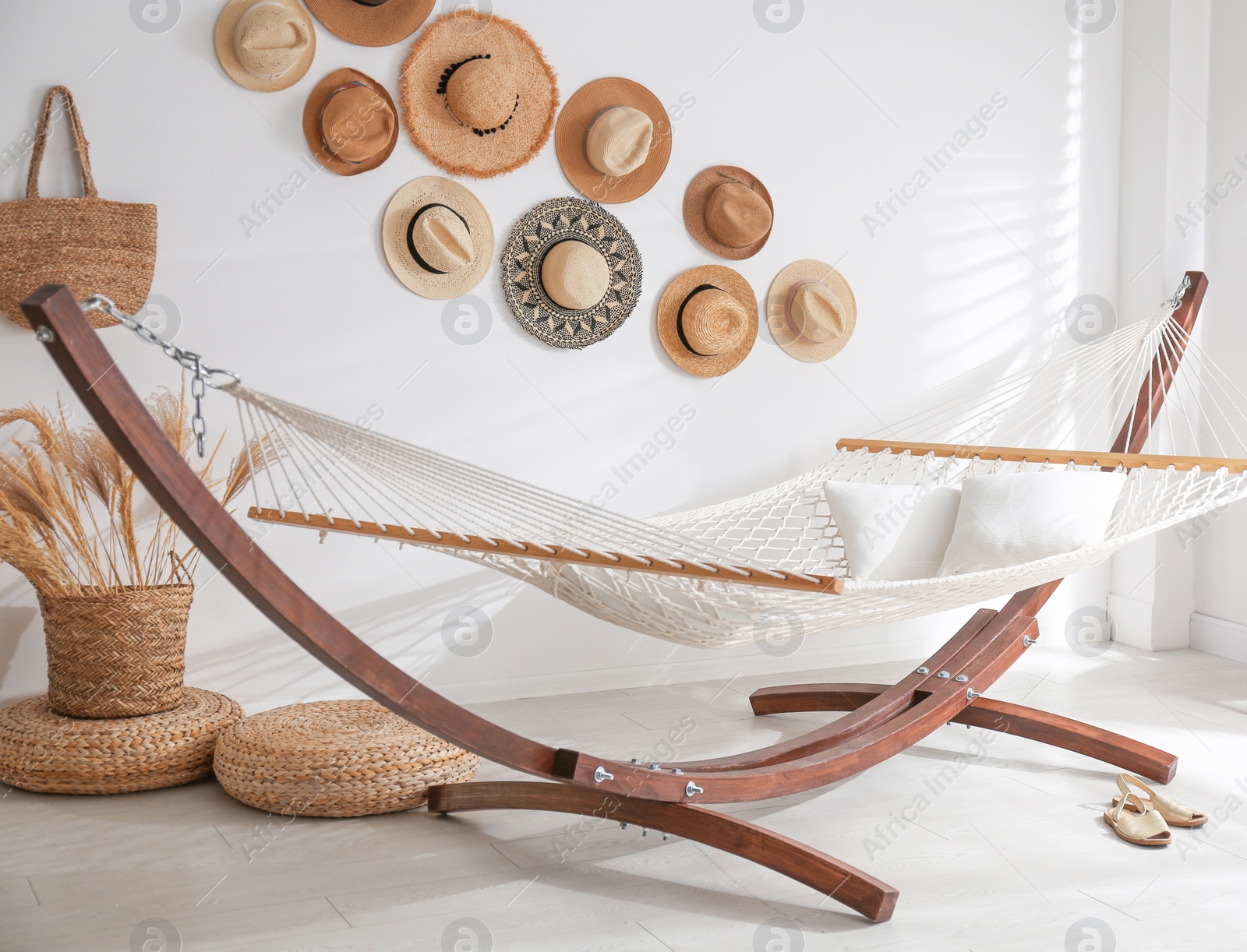 Photo of Comfortable hammock with pillows in stylish room. Interior design