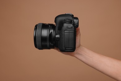 Photo of Photographer with camera on brown background, closeup