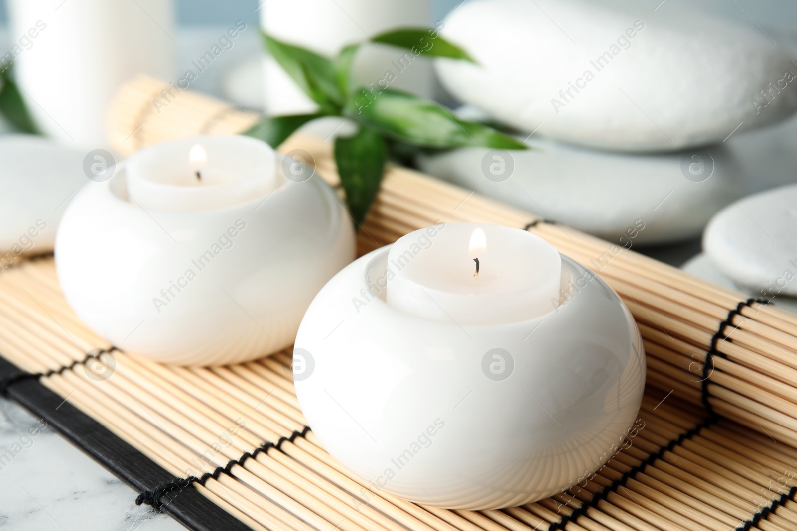 Photo of Beautiful spa composition with candles and bamboo mat on table