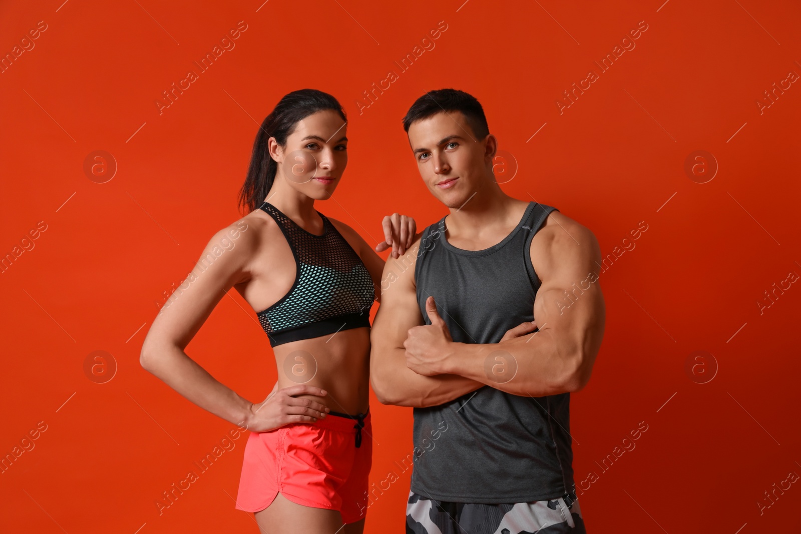 Photo of Portrait of athletic young people on red background. Running competition