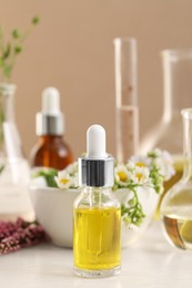 Photo of Bottle of cosmetic oil on white table