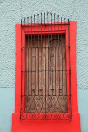 Light blue building with beautiful window and steel grilles