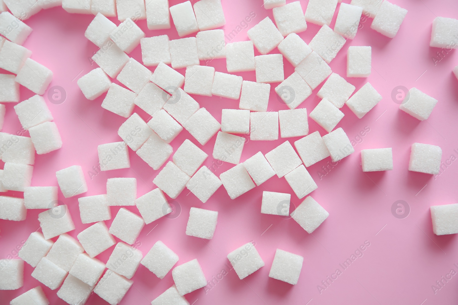 Photo of Refined sugar cubes on color background, top view