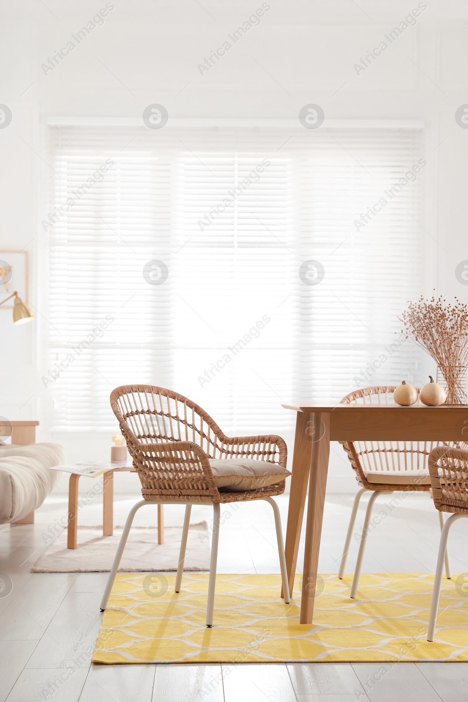 Photo of Dining room interior with wooden table and wicker chairs