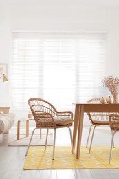 Dining room interior with wooden table and wicker chairs