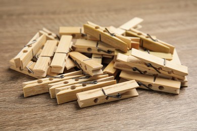 Pile of clothes pins on wooden table, closeup