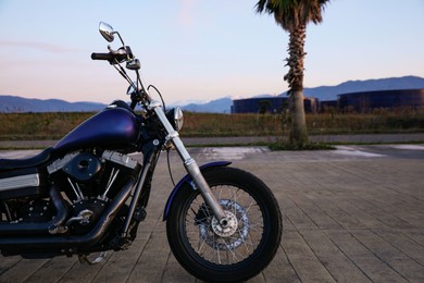 Photo of Modern black motorcycle parked near road outdoors