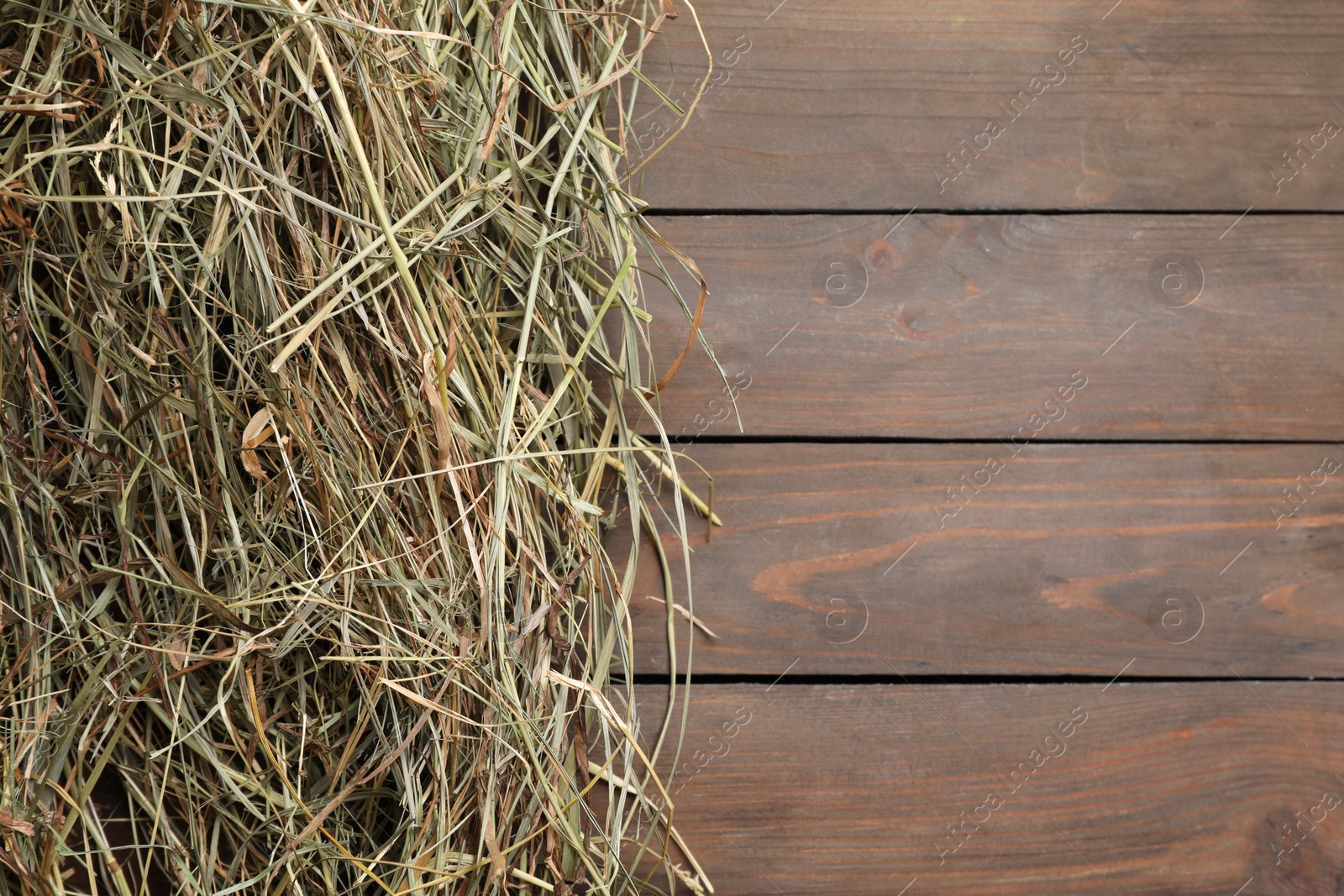 Photo of Heap of dried hay on wooden table, top view. Space for text