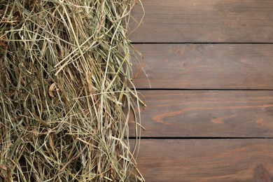 Heap of dried hay on wooden table, top view. Space for text