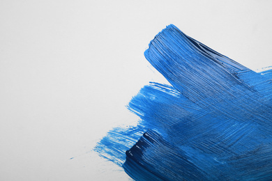 Photo of Paint strokes on white background background, top view. Color of the year 2020 (Classic blue)