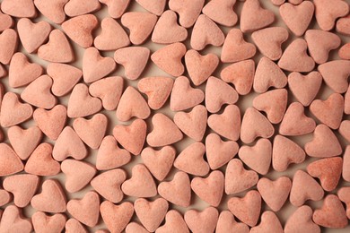 Photo of Many heart shaped vitamins for pets on beige background, flat lay