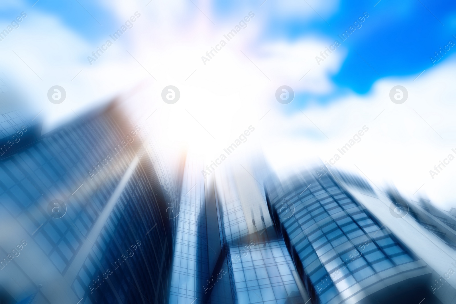 Image of Blurred view of modern skyscraper with tinted windows against blue sky, low angle view. Building corporation