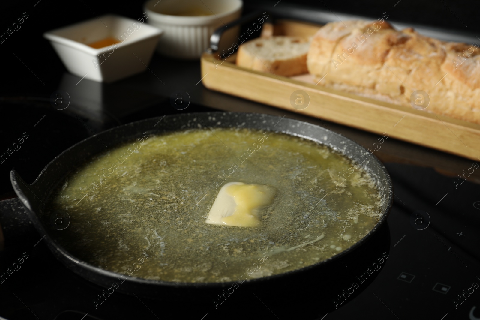 Photo of Melting butter in frying pan on cooktop, closeup