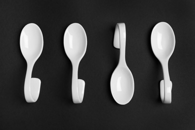 Photo of Ceramic serving spoons on black background, flat lay