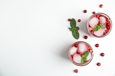 Tasty refreshing cranberry cocktail with mint on white table, flat lay. Space for text