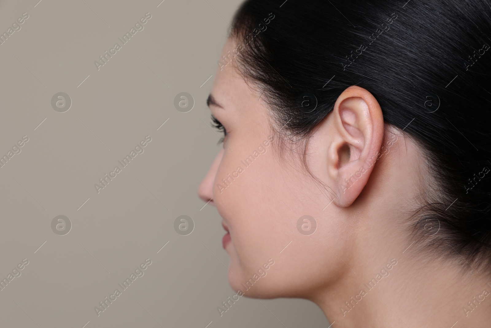Photo of Young woman on grey background, closeup. Space for text