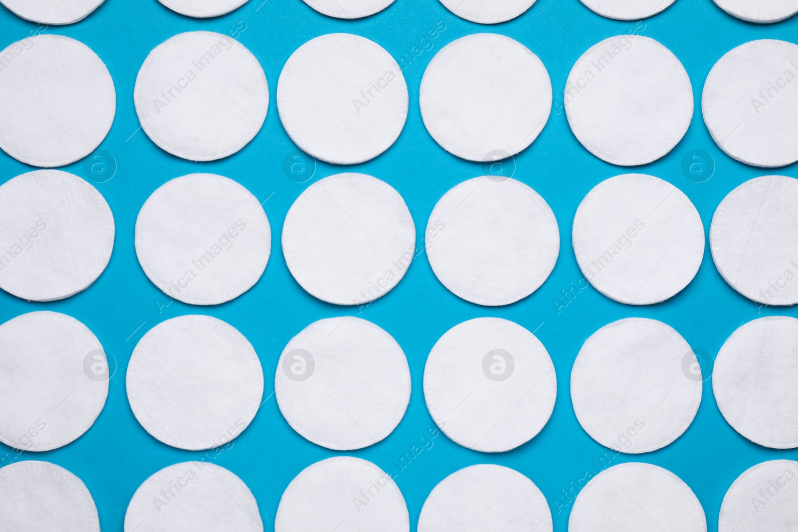 Photo of Many cotton pads on light blue background, flat lay