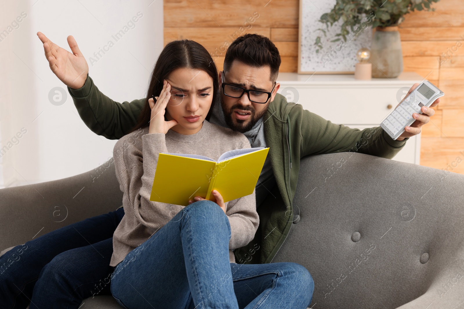 Photo of Young couple discussing family budget at home