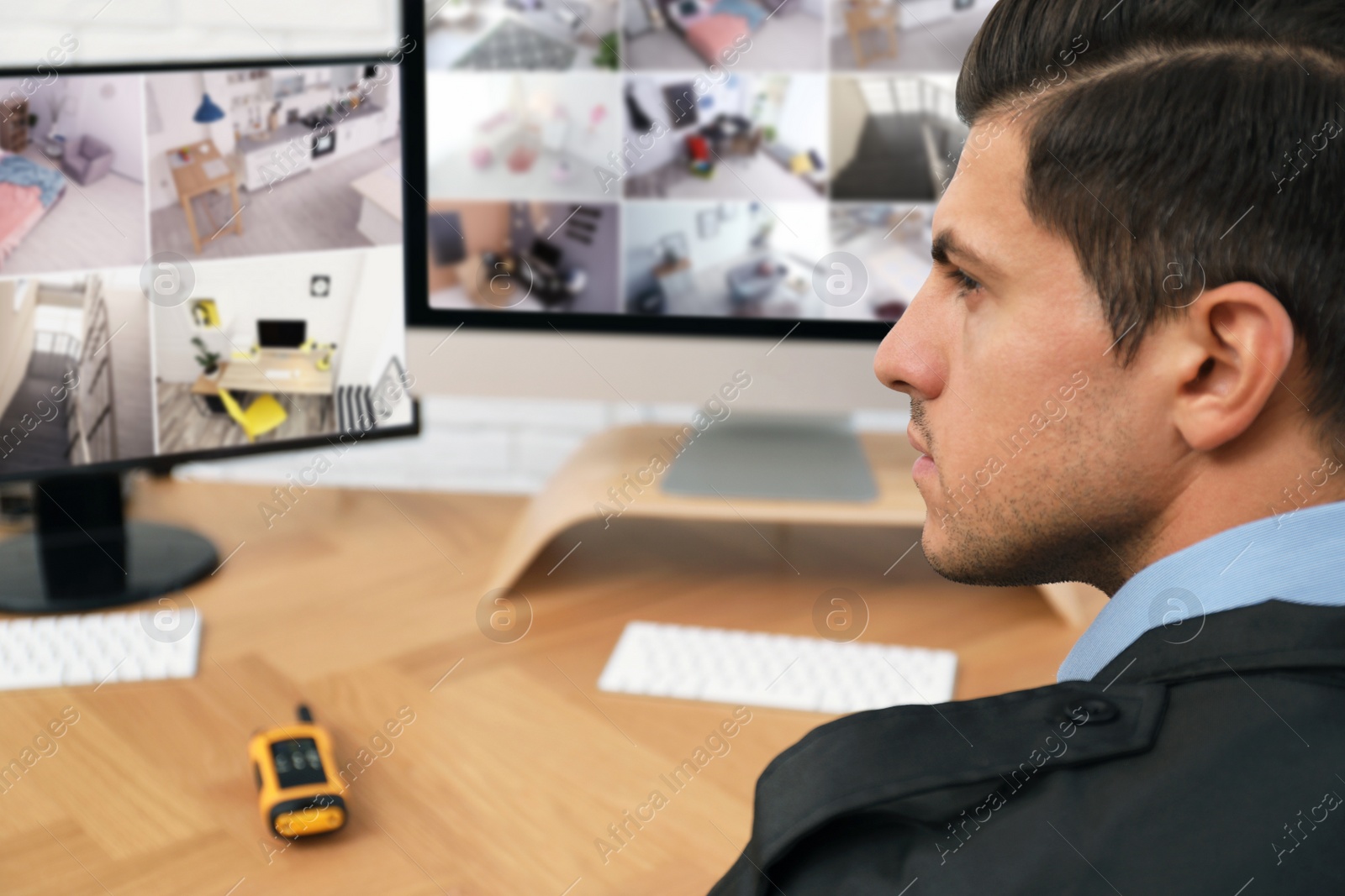 Photo of Male security guard monitoring cameras at workplace, closeup