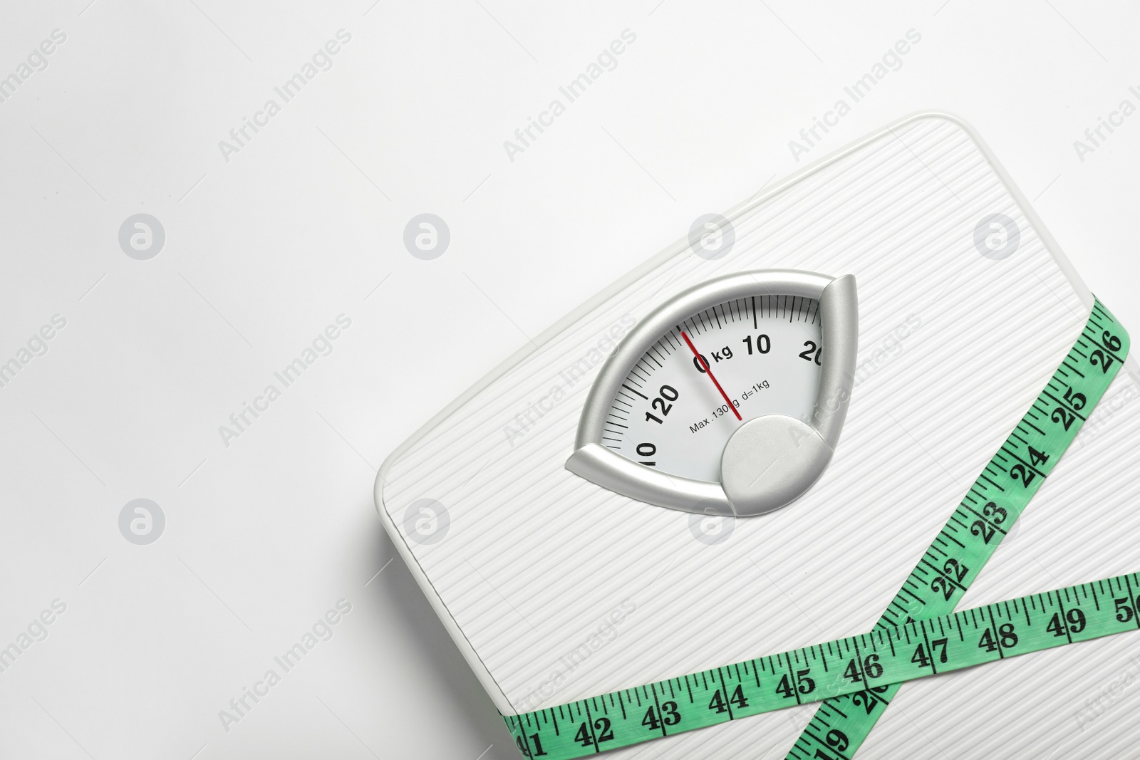 Photo of Weight loss concept. Scales and measuring tape on white background, top view. Space for text