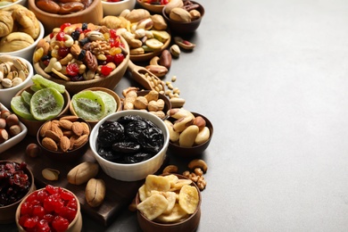 Photo of Composition of different dried fruits and nuts on color background. Space for text