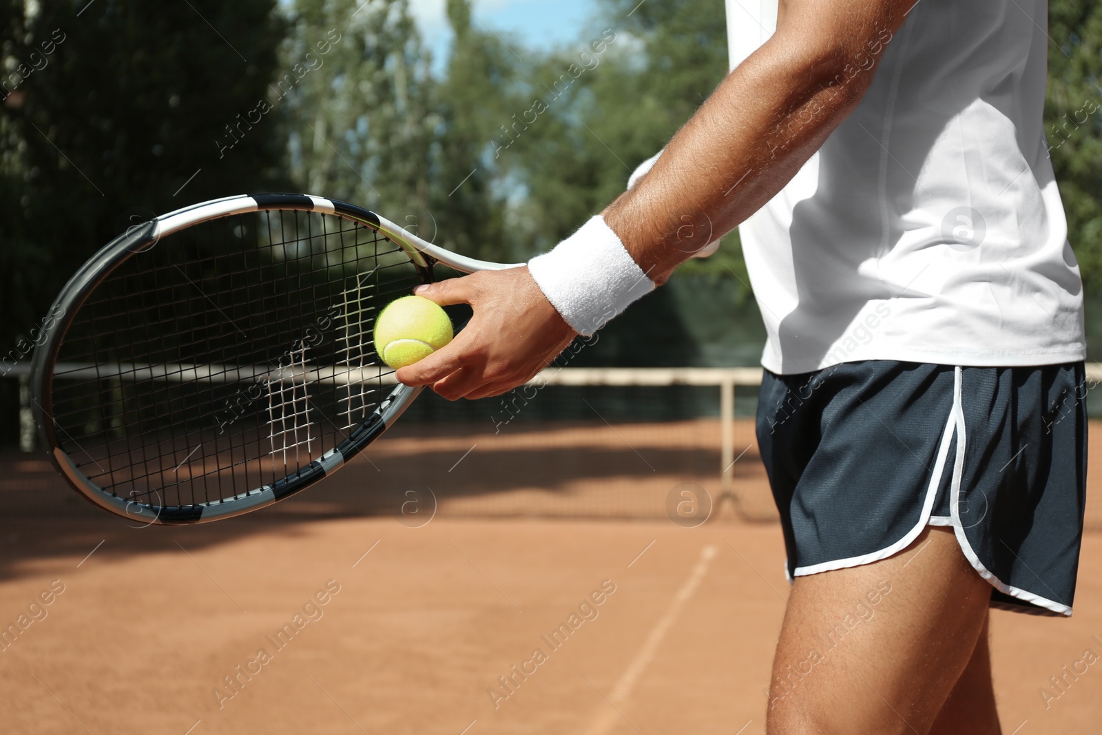 Photo of Sportsman preparing to serve tennis ball at court, closeup