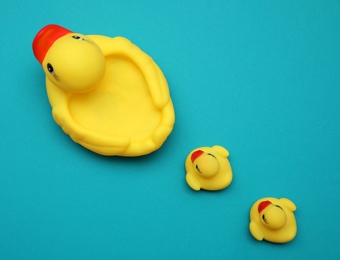 Photo of Rubber toy ducks on teal background, flat lay