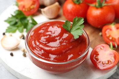 Photo of Delicious tomato ketchup and parsley in bowl on light table, closeup