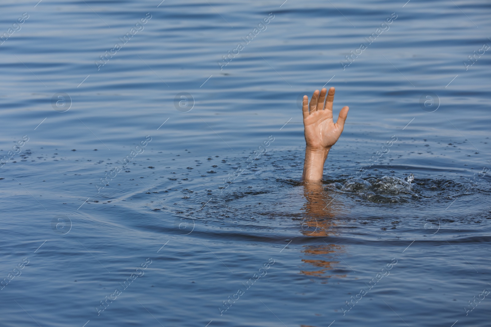 Photo of Drowning man reaching for help in sea, closeup