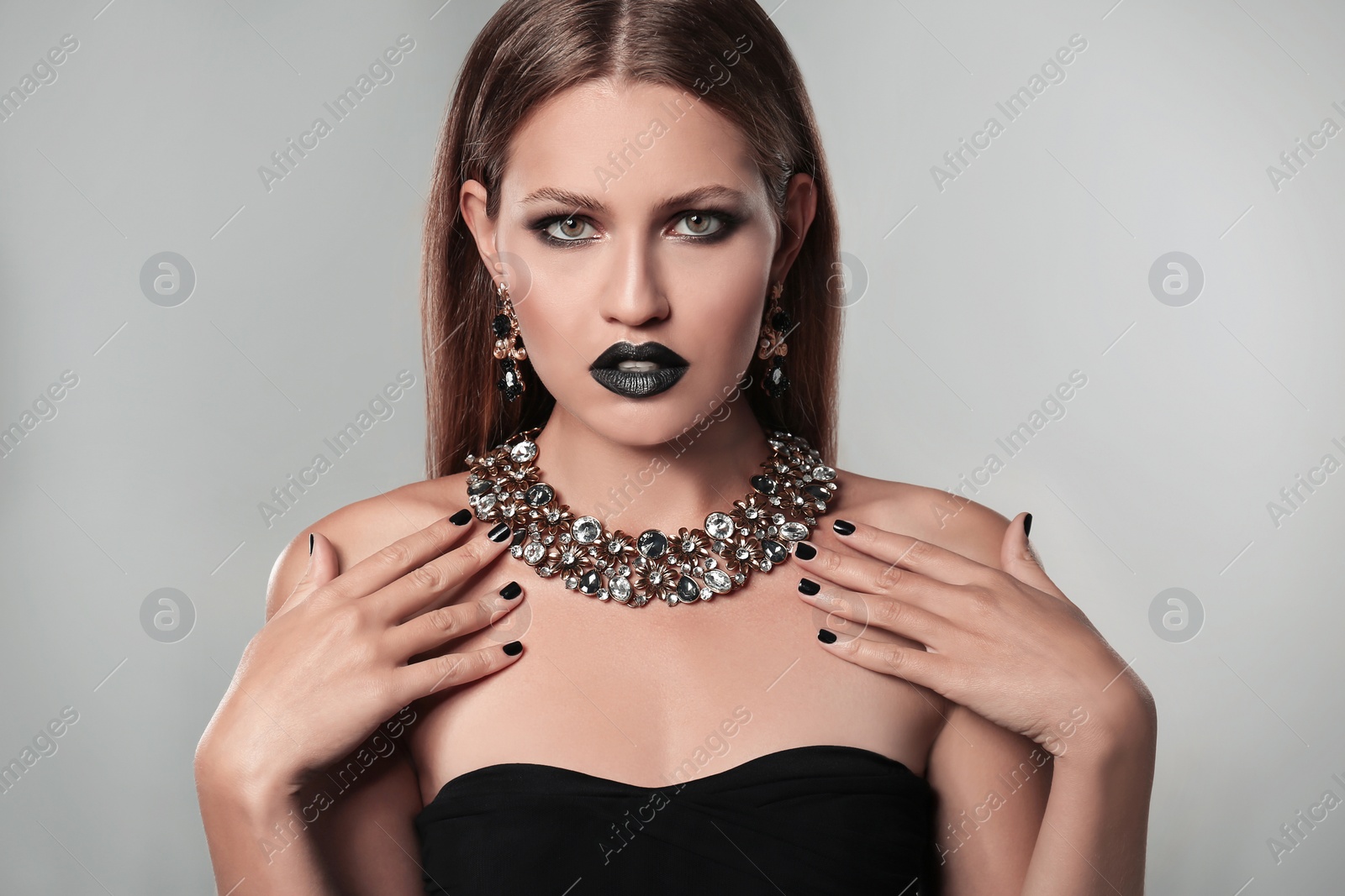 Photo of Beautiful woman with stylish jewelry on grey background