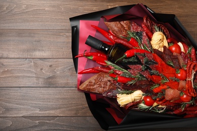 Beautiful edible bouquet with meat, cheese and vegetables on wooden table, top view. Space for text