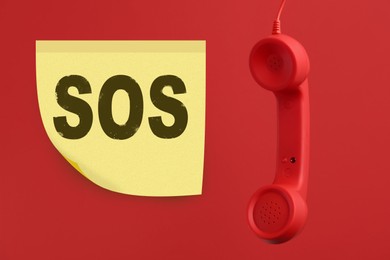Image of Telephone handset on red background. Emergency SOS call