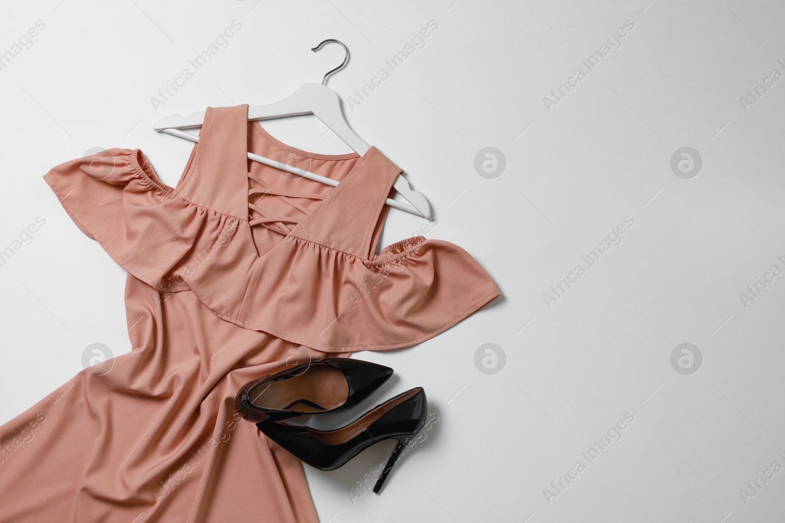 Photo of Stylish outfit with beautiful dress on white background, top view. Rental clothing service