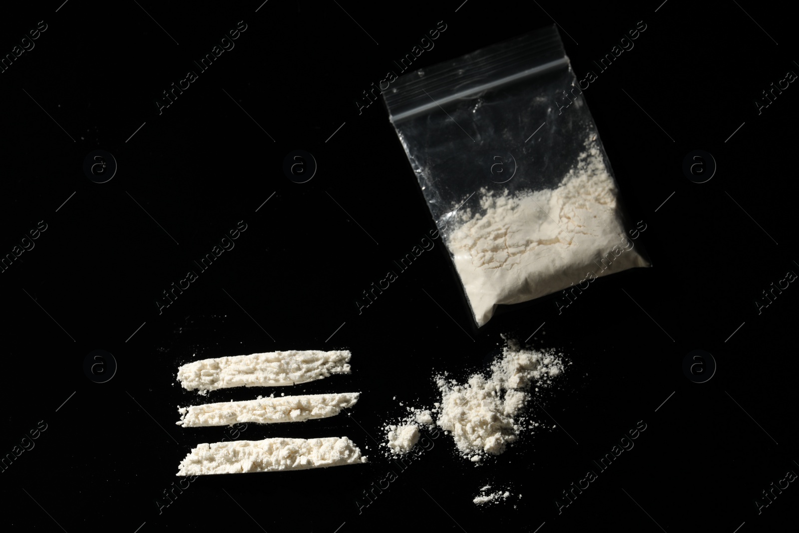 Photo of Drug addiction. Plastic bag with cocaine on black background, flat lay