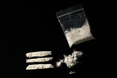 Drug addiction. Plastic bag with cocaine on black background, flat lay