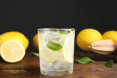 Photo of Cool freshly made lemonade and fruits on wooden table