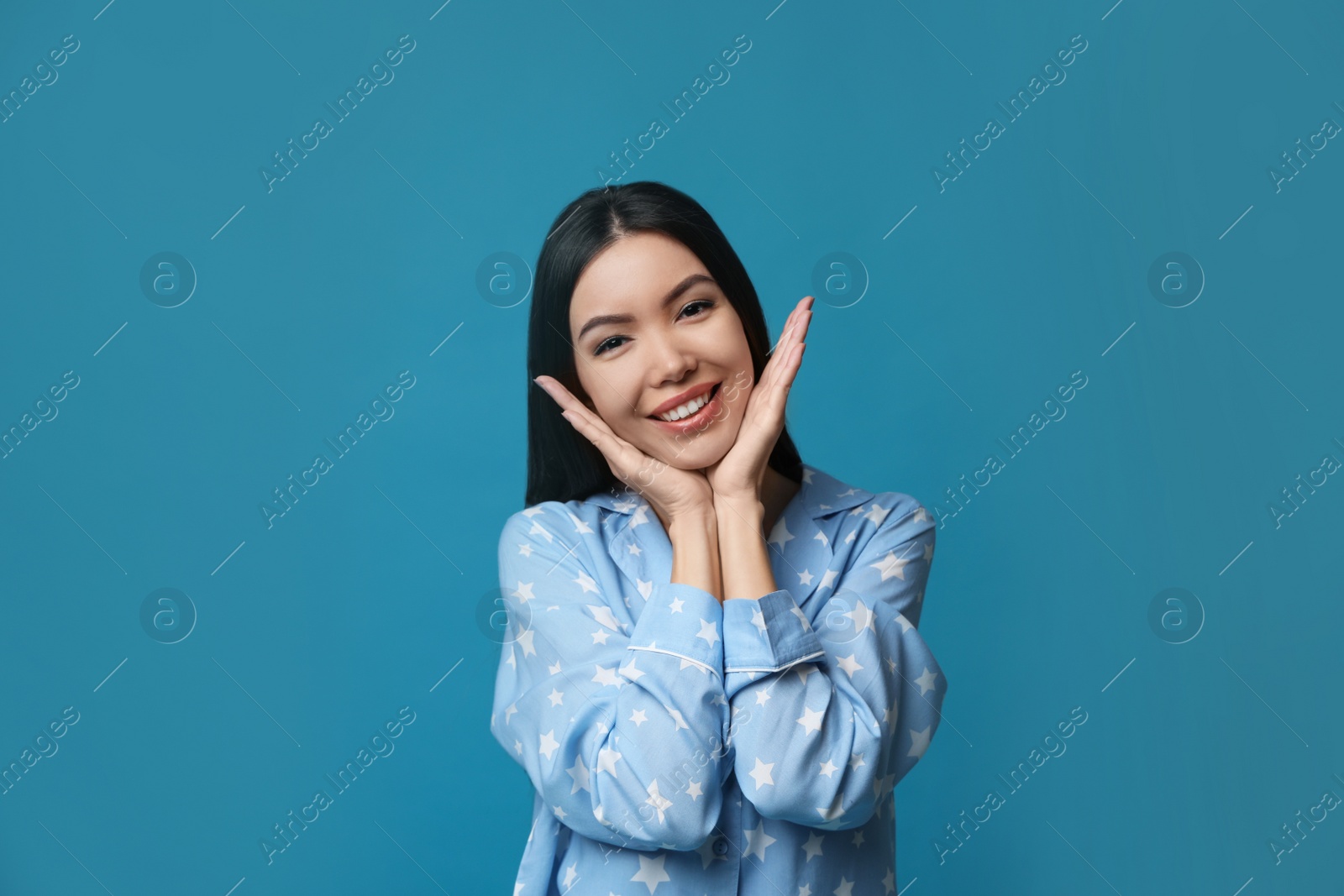 Photo of Beautiful Asian woman wearing pajamas on blue background. Bedtime